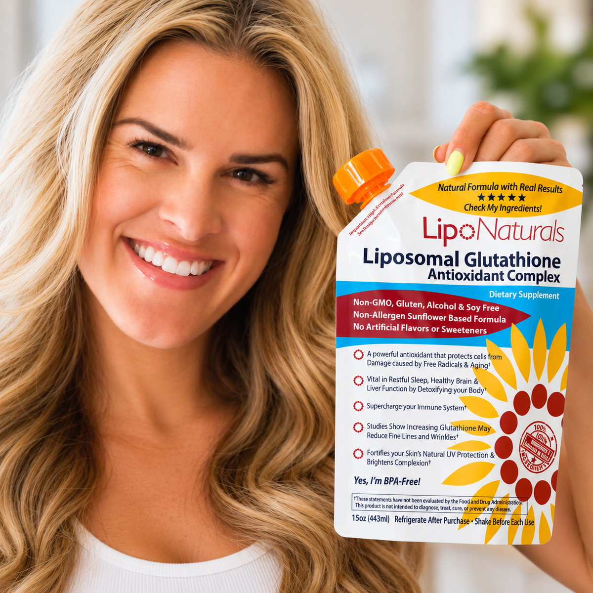 A smiling blonde woman holds up a bottle of Lipo Naturals Liposomal Glutathione Antioxidant Complex against a soft-focus indoor background.